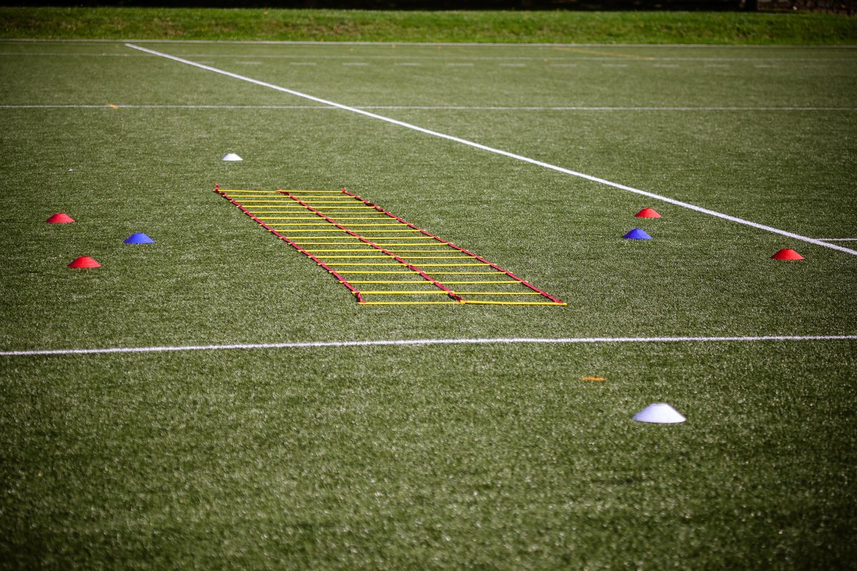 Plots et échelle de rythme installés sur un terrain d'entraînement